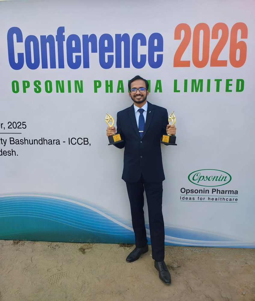Sayedul Abrar holding two award trophies in front of the Opsonin Pharma Conference 2026 backdrop