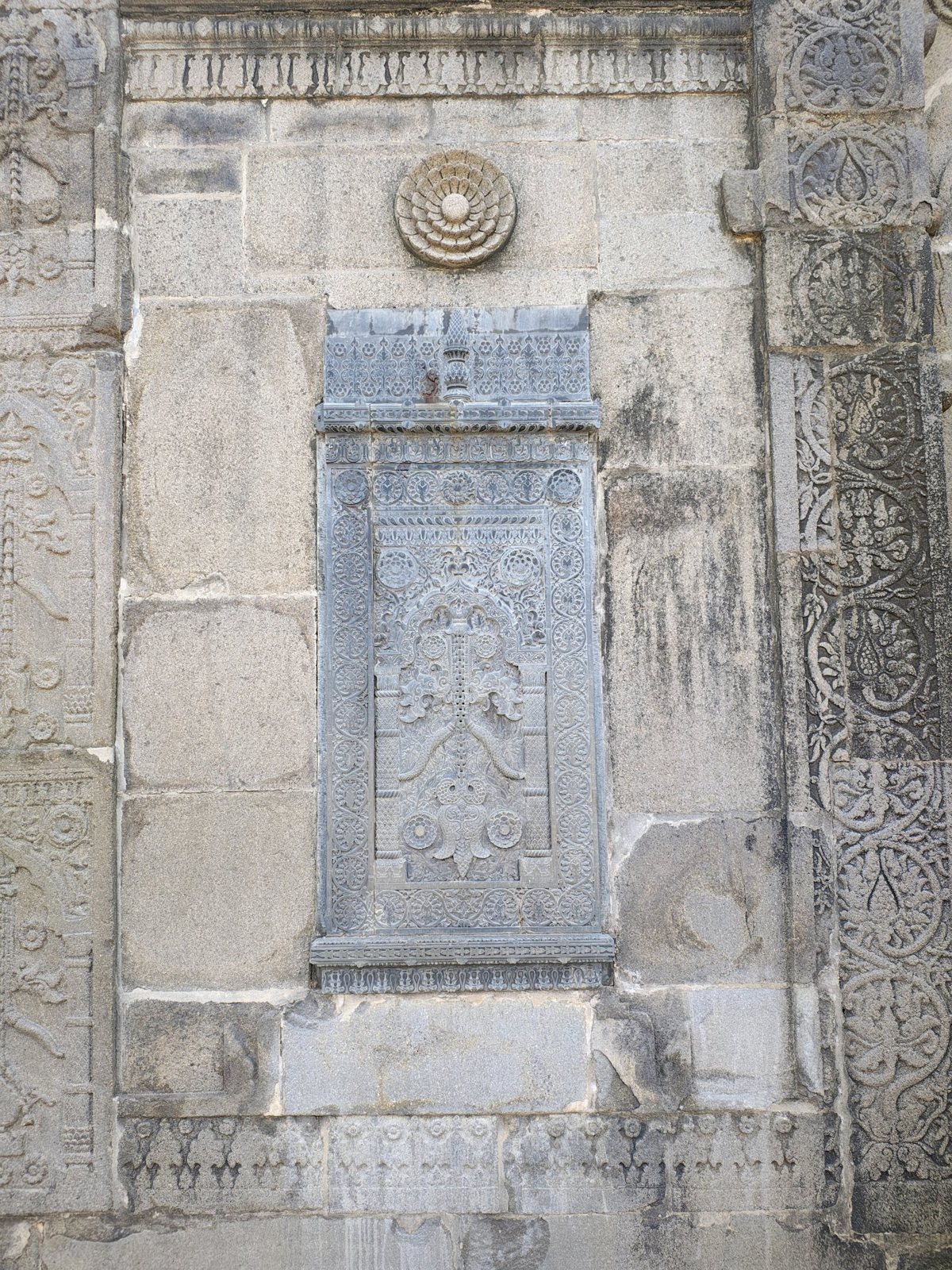 Close-up of floral and arch motifs carved into the outer wall of Sona Masjid