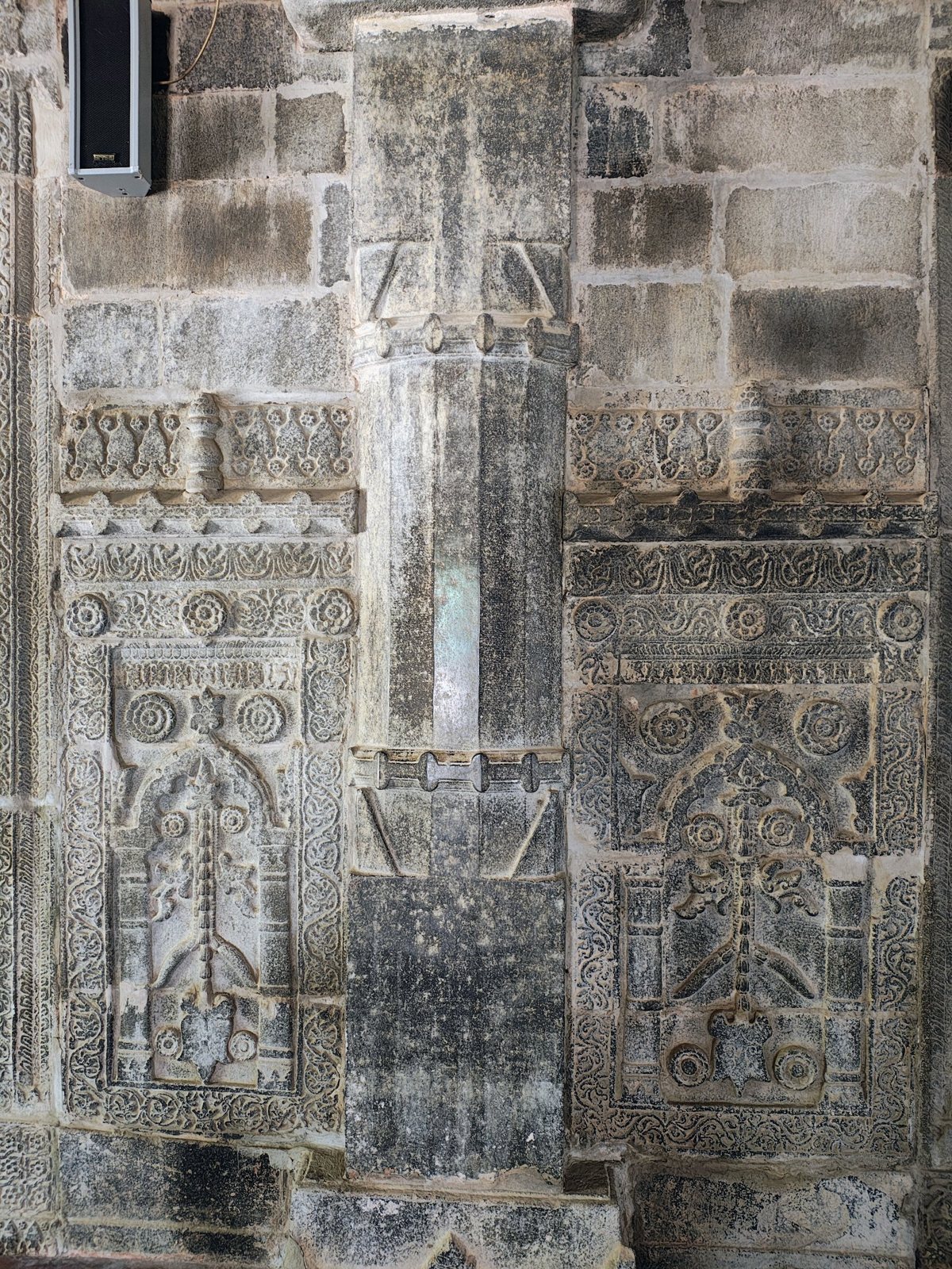 Carved stone wall panels and central column inside Sona Masjid, Chapainawabganj